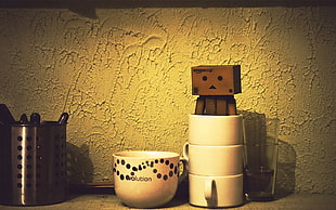 white ceramic mug with robot toy